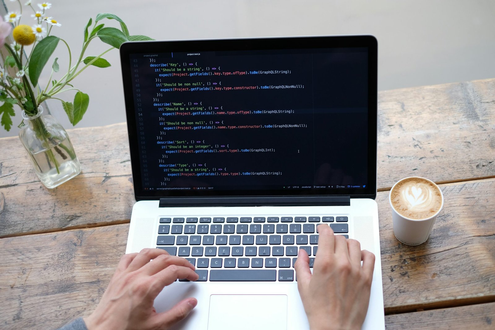 person using macbook pro on brown wooden table